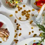 Elegant holiday dining setup with assorted dishes, candles, and festive decorations.