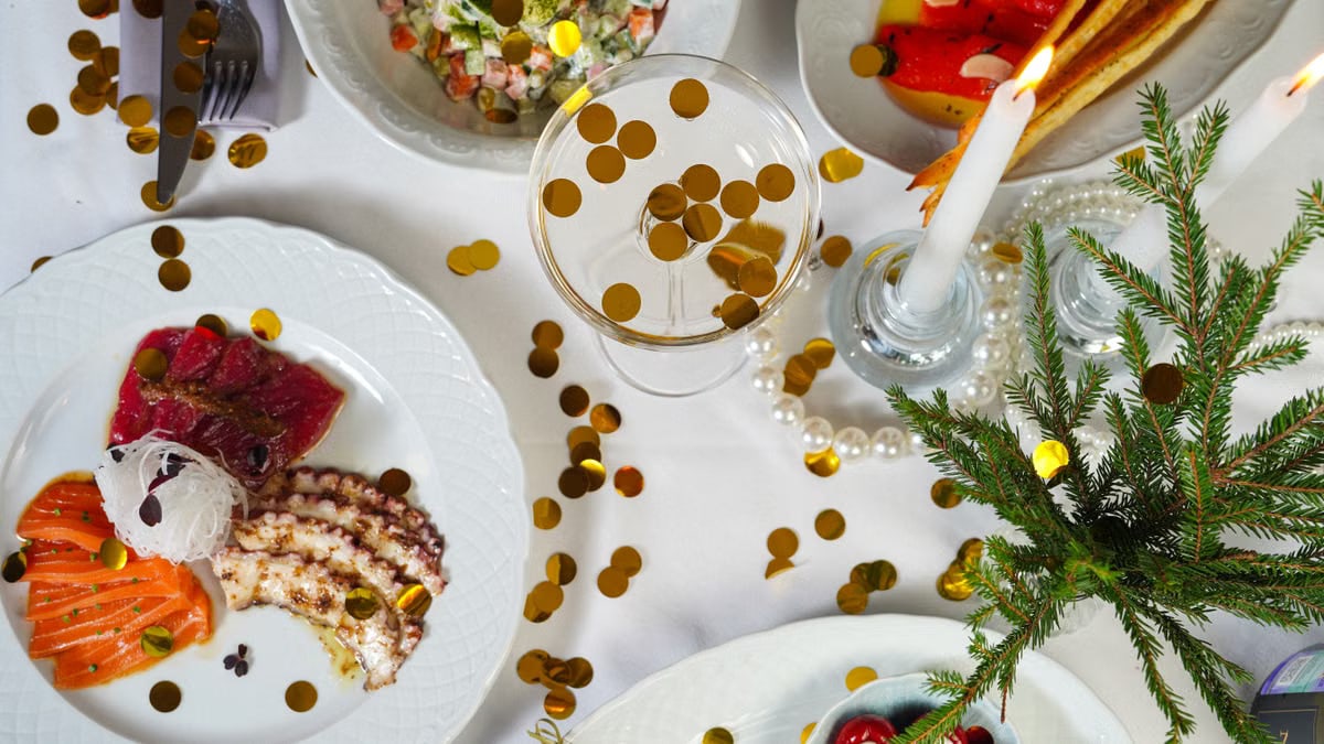 Elegant holiday dining setup with assorted dishes, candles, and festive decorations.